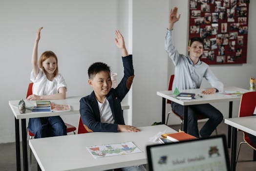 Diverse group of students actively participating in a classroom setting, raising hands for recitation.